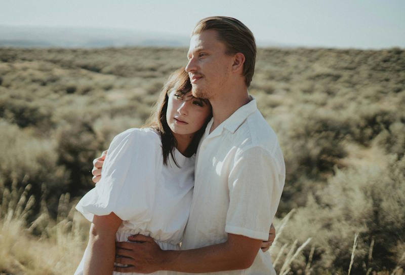 Couple complice s’enlaçant tendrement dans la nature, illustrant les clés essentielles pour faire fonctionner une relation de couple