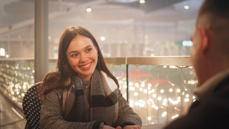 Femme souriante discutant avec son partenaire dans une ambiance détendue, sans percevoir les signes possibles d’abus psychologique